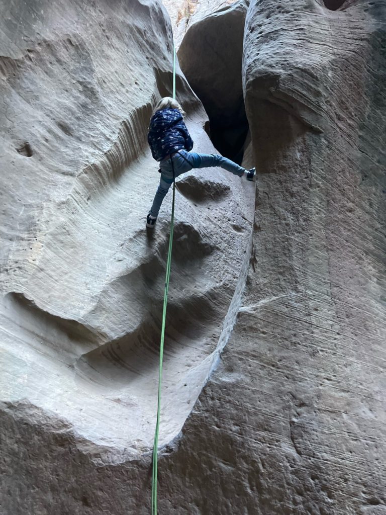 Child rappelling in a slot canyon